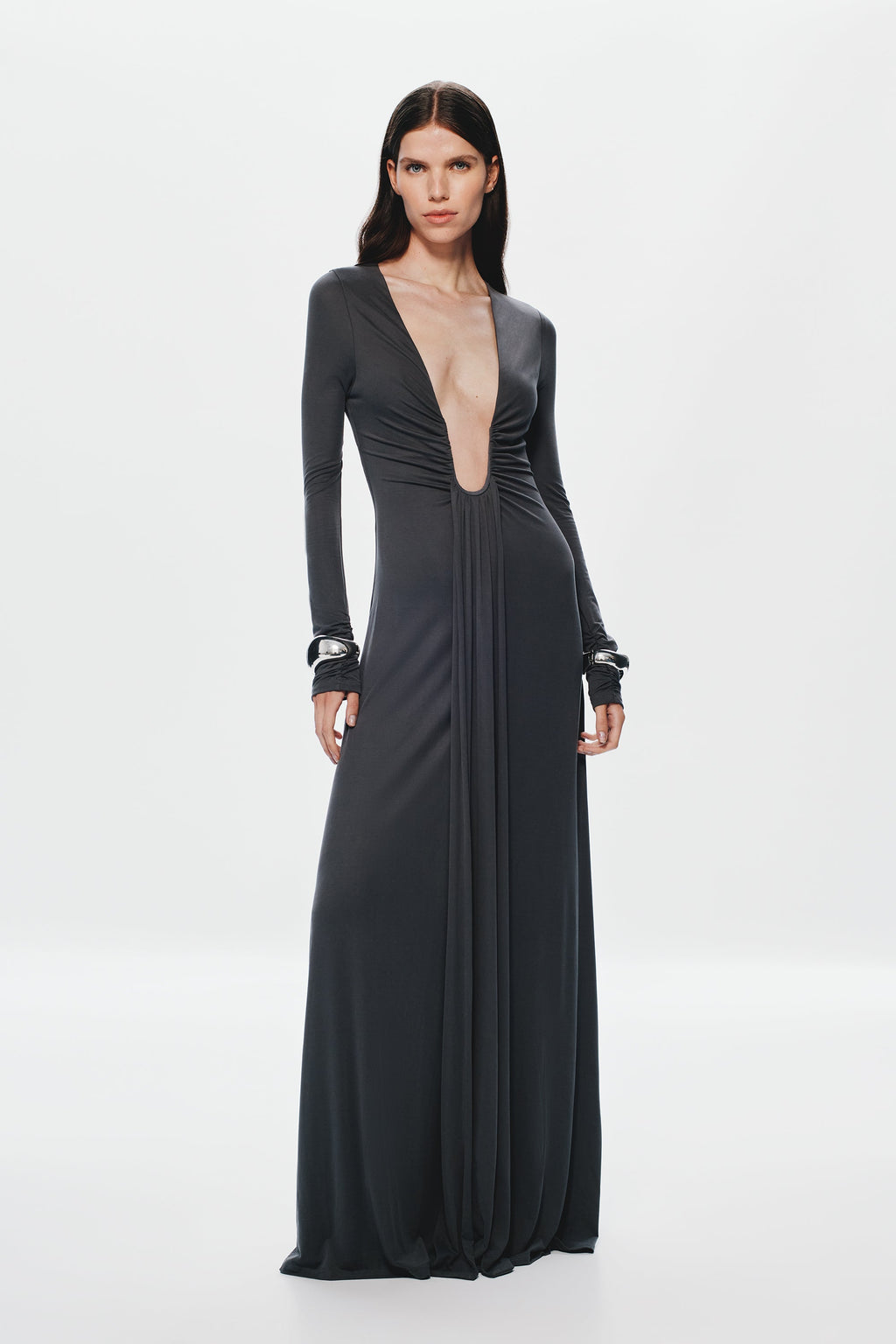 Dark long-sleeve maxi dress with deep V front, gathered waist, and flowing skirt.