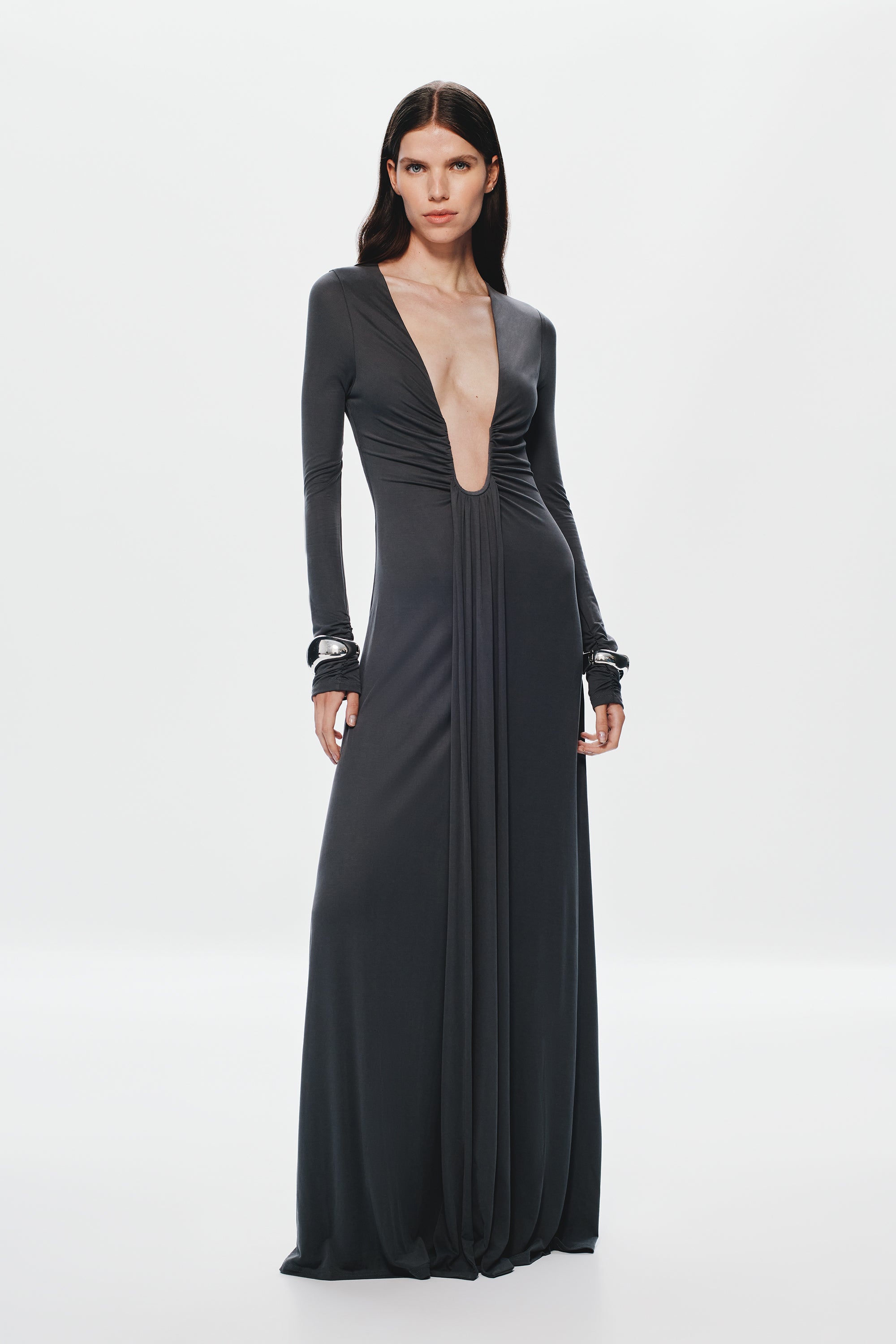 Dark long-sleeve maxi dress with deep V front, gathered waist, and flowing skirt.