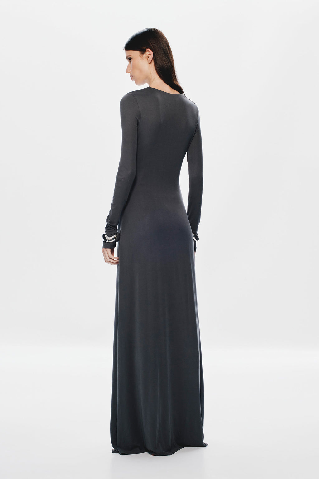 Dark long-sleeve maxi dress with smooth back and long column hemline.