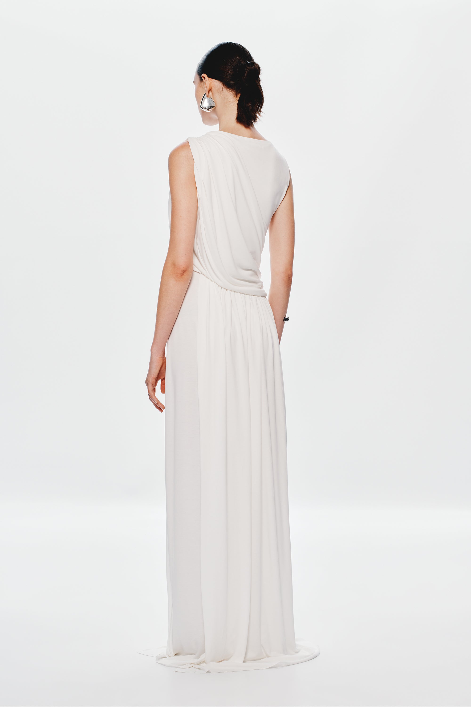 Ivory sleeveless maxi dress with draped back and gathered waist, pleated skirt