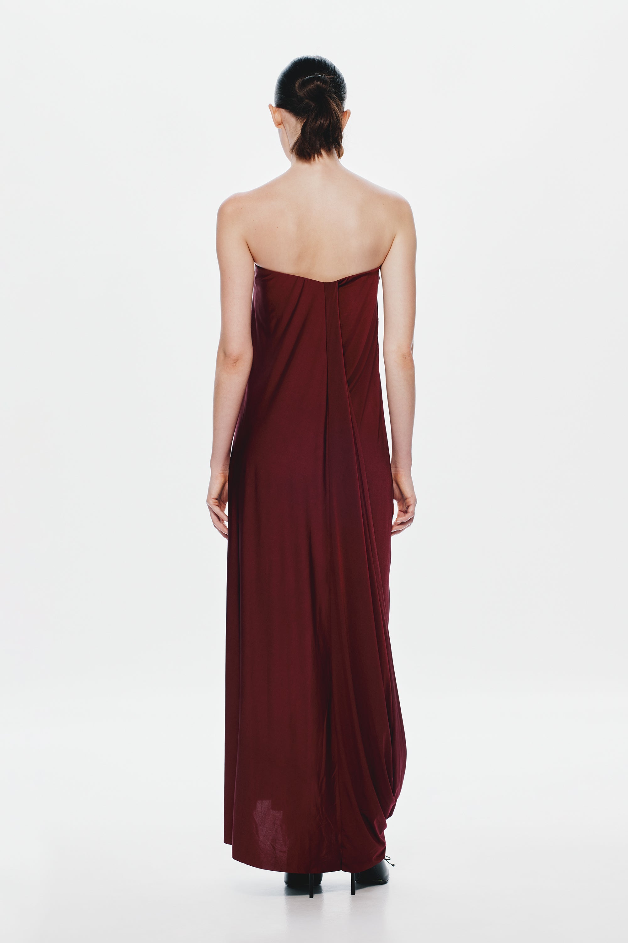 Burgundy strapless jersey maxi dress with cross-back paneling and draped skirt