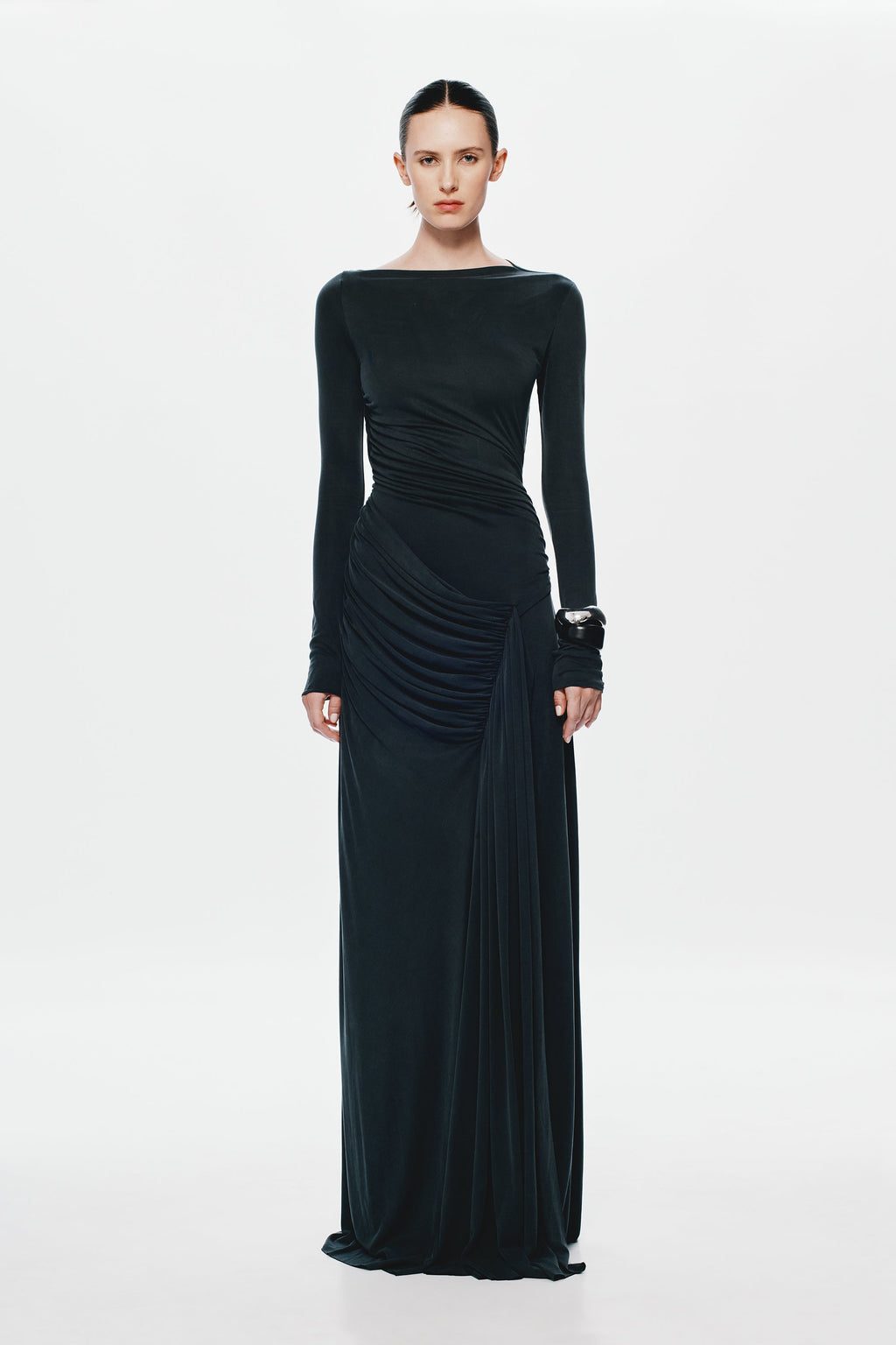 Black long-sleeve maxi dress with ruched waist, diagonal drape, and gathered skirt