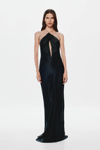 Black satin halter gown with center front slit-like opening and long column silhouette.