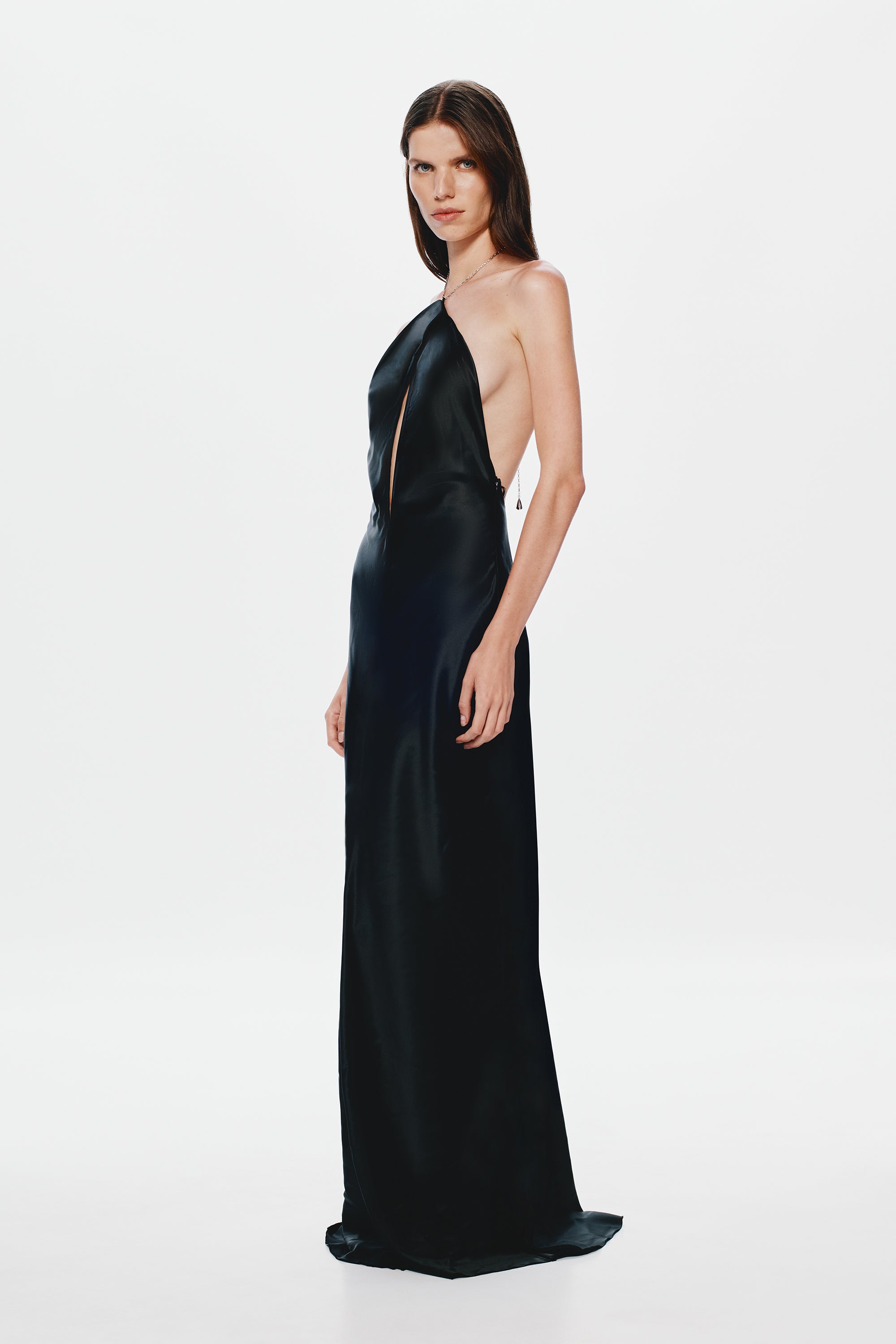 Black satin halter gown, sleeveless column fit with draped front seam detail.