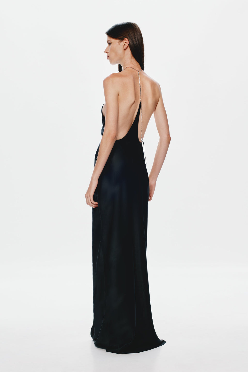 Black satin halter gown with open back, racerback straps, and floor-length column shape.