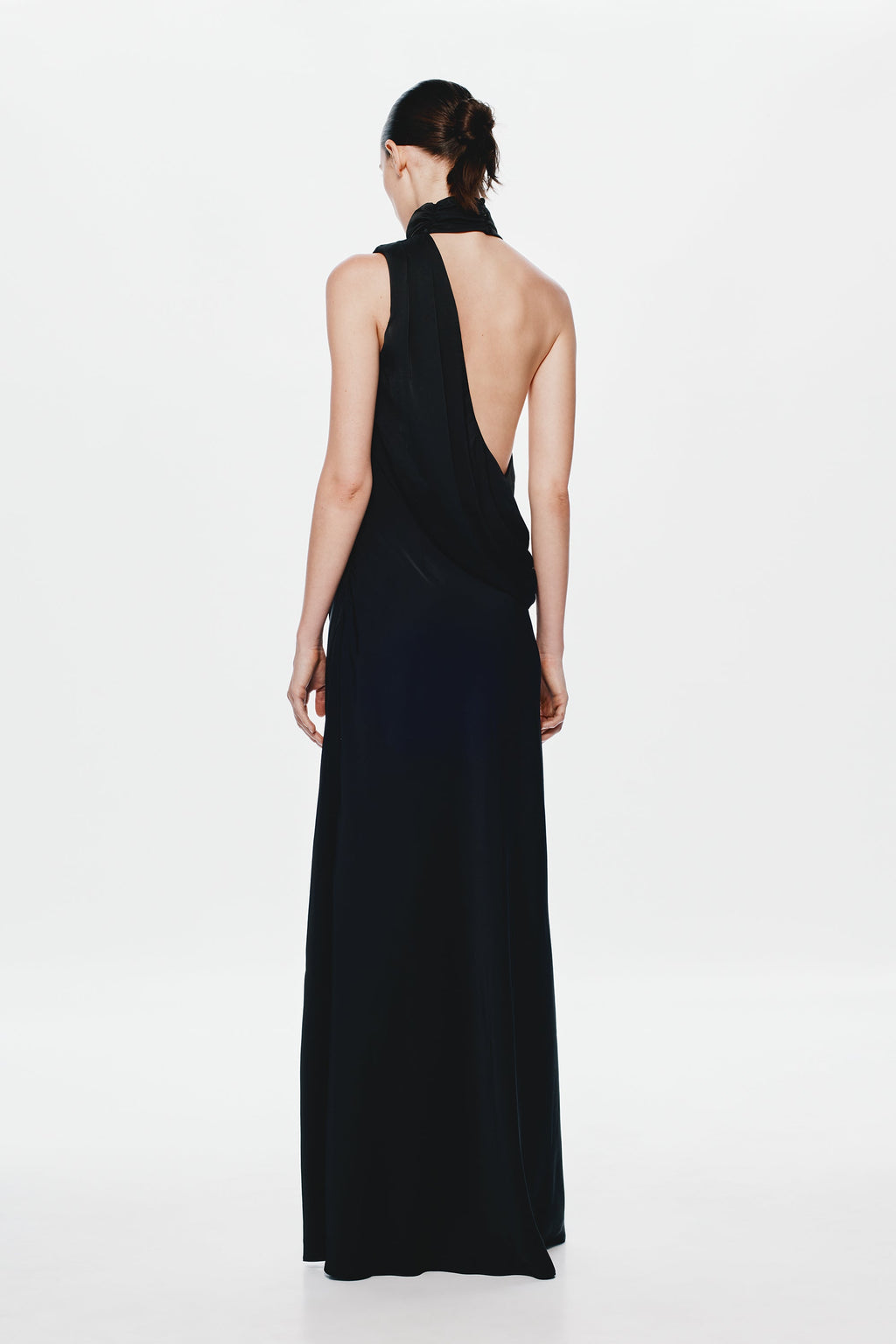 Back view of black satin sleeveless maxi dress with open back and draped neck