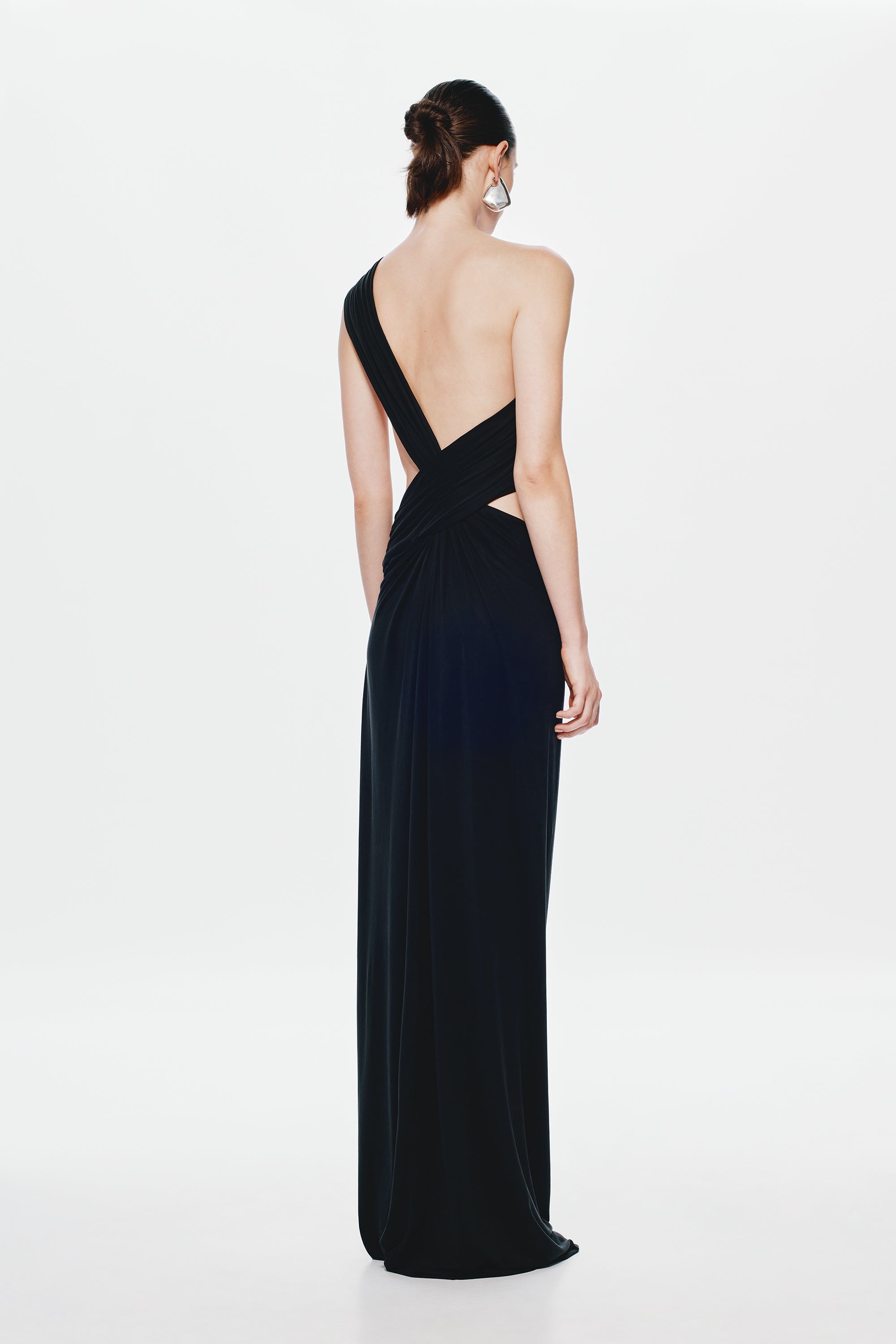 Black sleeveless maxi dress with open back and V-shaped strap, draped asymmetry