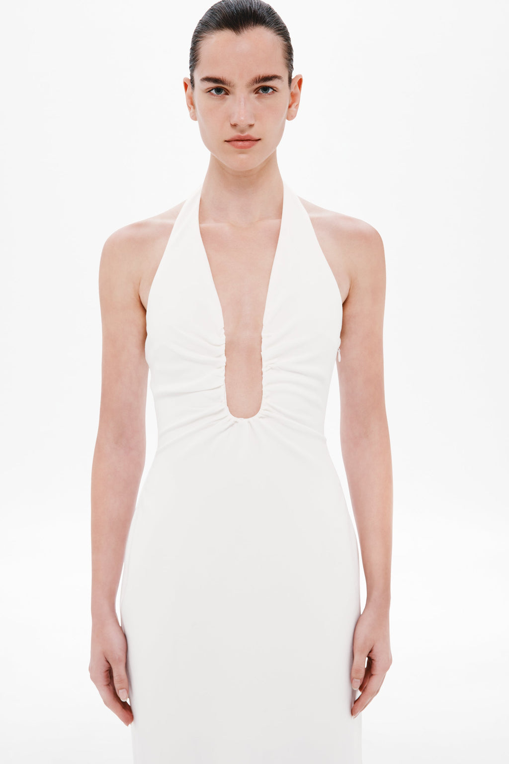 Ivory halter dress with ruched neckline and sleeveless fitted bodice.