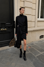 Black draped wool suiting skirt with side drape and angled asymmetrical hem