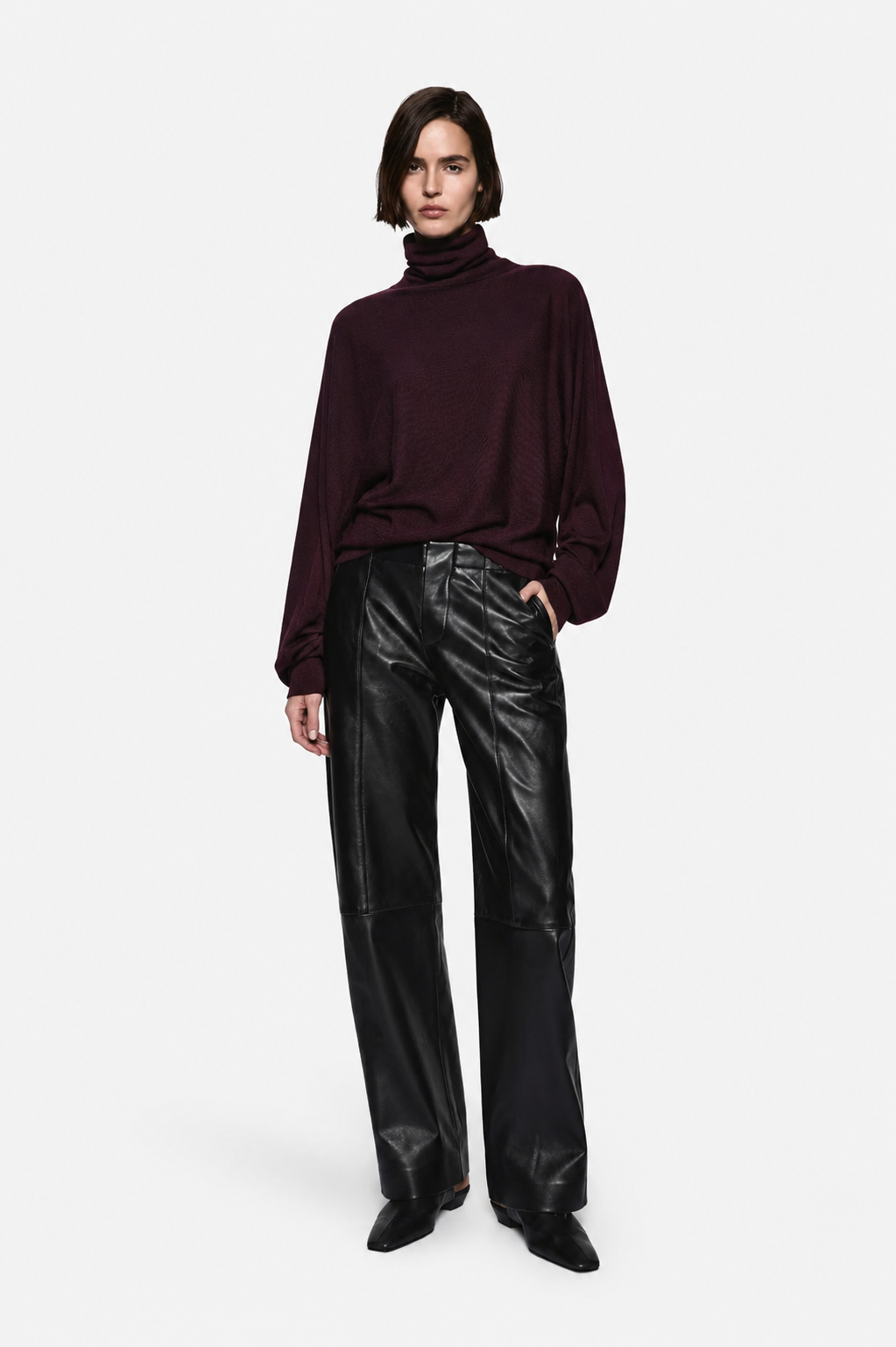 Black leather high-rise pants with belt loops and front crease seams