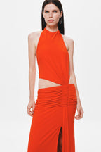 Sleeveless chili red halter jersey dress with ruched waist detail and flowing skirt panel