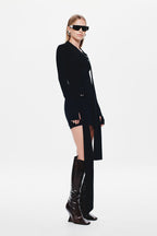 Black jersey mini dress with long sleeves and curved asymmetrical side opening