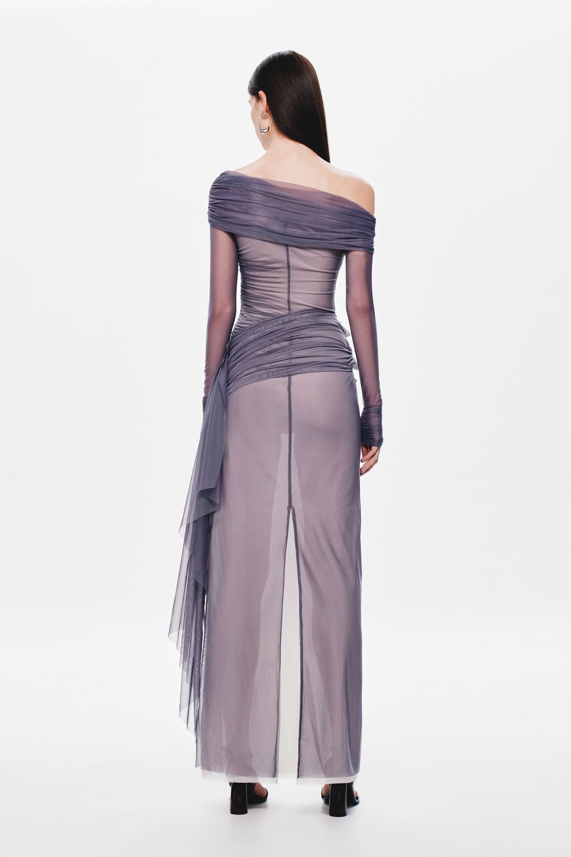 Back view of off-shoulder draped mesh dress with column skirt and sheer tulle hem detail.