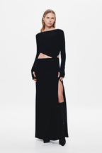 Black long-sleeve jersey maxi dress with one-shoulder neckline and waist cutout