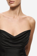 Close-up of black silk dress with draped cowl strapless neckline