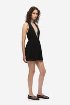Black halter mini dress with deep V neckline and lightly pleated skirt