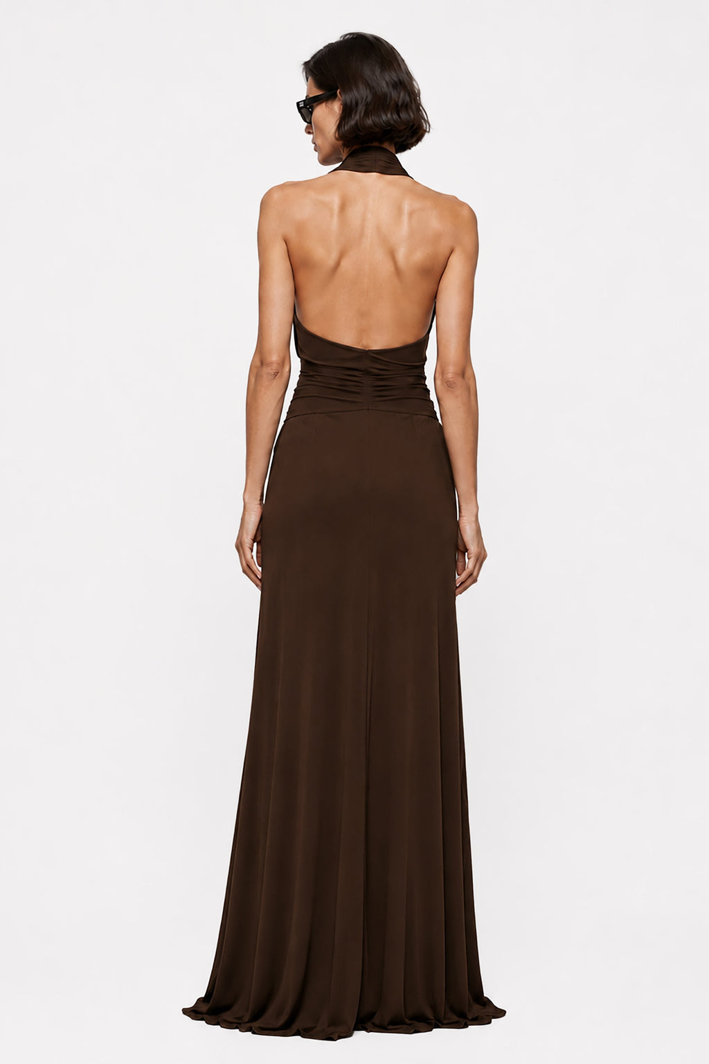 Open-back chocolate halter gown with fitted waist and flowing skirt, full length