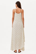Ivory maxi dress back view with thin straps, draped hem, and small dot print