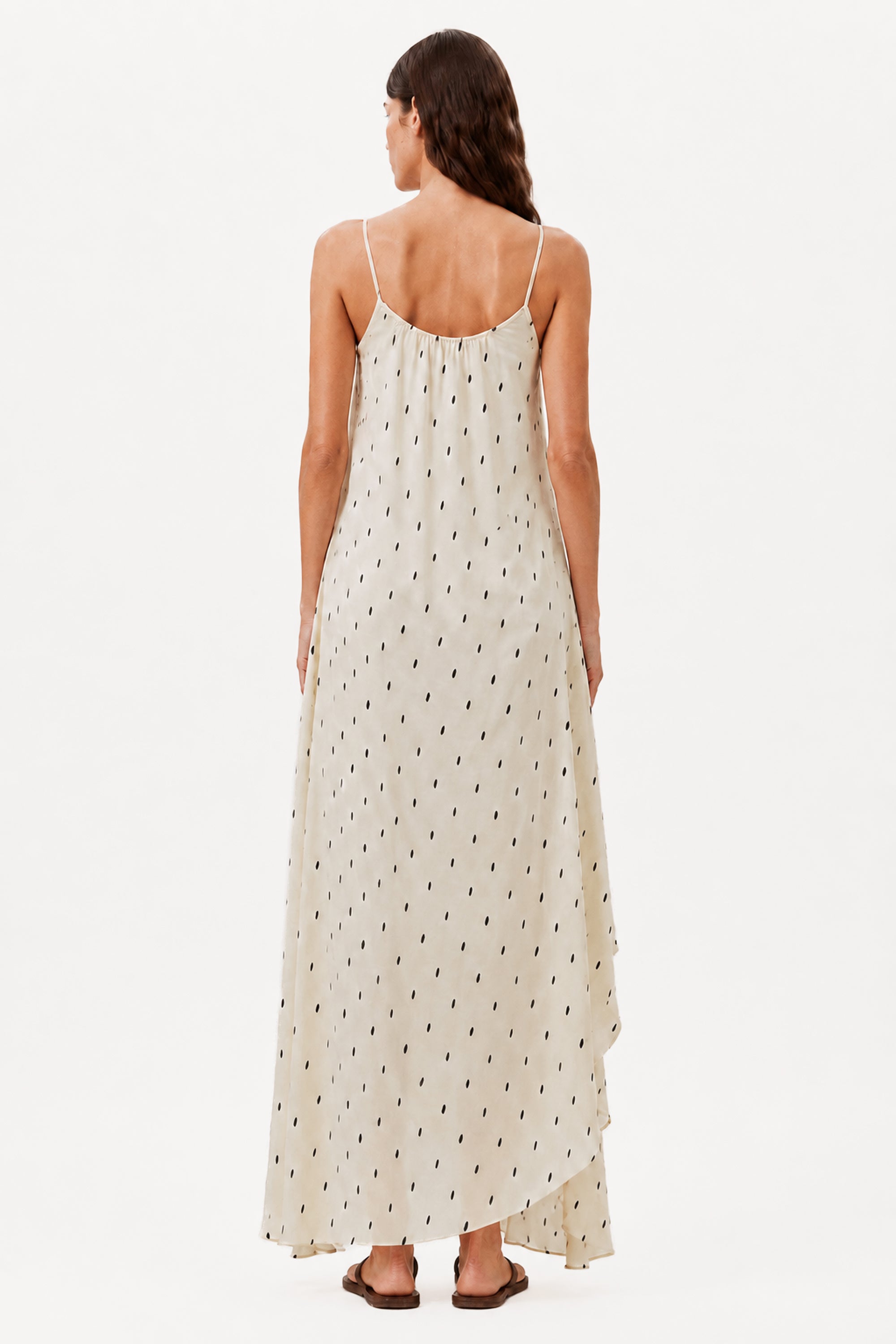 Ivory maxi dress back view with thin straps, draped hem, and small dot print