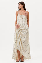 Ivory maxi dress with spaghetti straps, allover tiny print, and pink rosette details