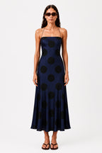 Navy polka dot midi dress with spaghetti straps and square neckline, bias cut hem flare