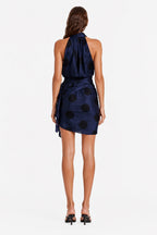 Navy polka dot wrap mini dress, sleeveless open-back style with waist drape