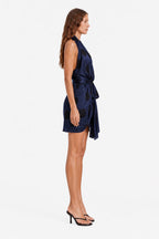 Navy polka dot wrap mini dress, sleeveless side view with draped waist tie