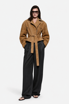 Tan suede leather jacket with belt tie at waist, notched collar, and zipper front
