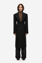 Black long coat with notched lapels, button front, and belted waist