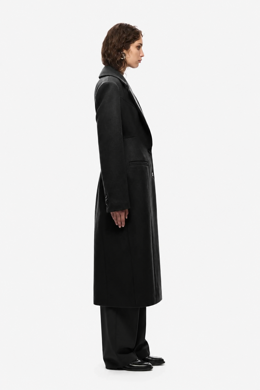 Black long tailored coat with notched lapels and side seam detail