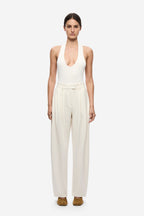 Ivory pleated barrel-leg trousers with high waist and drapey wide-leg silhouette