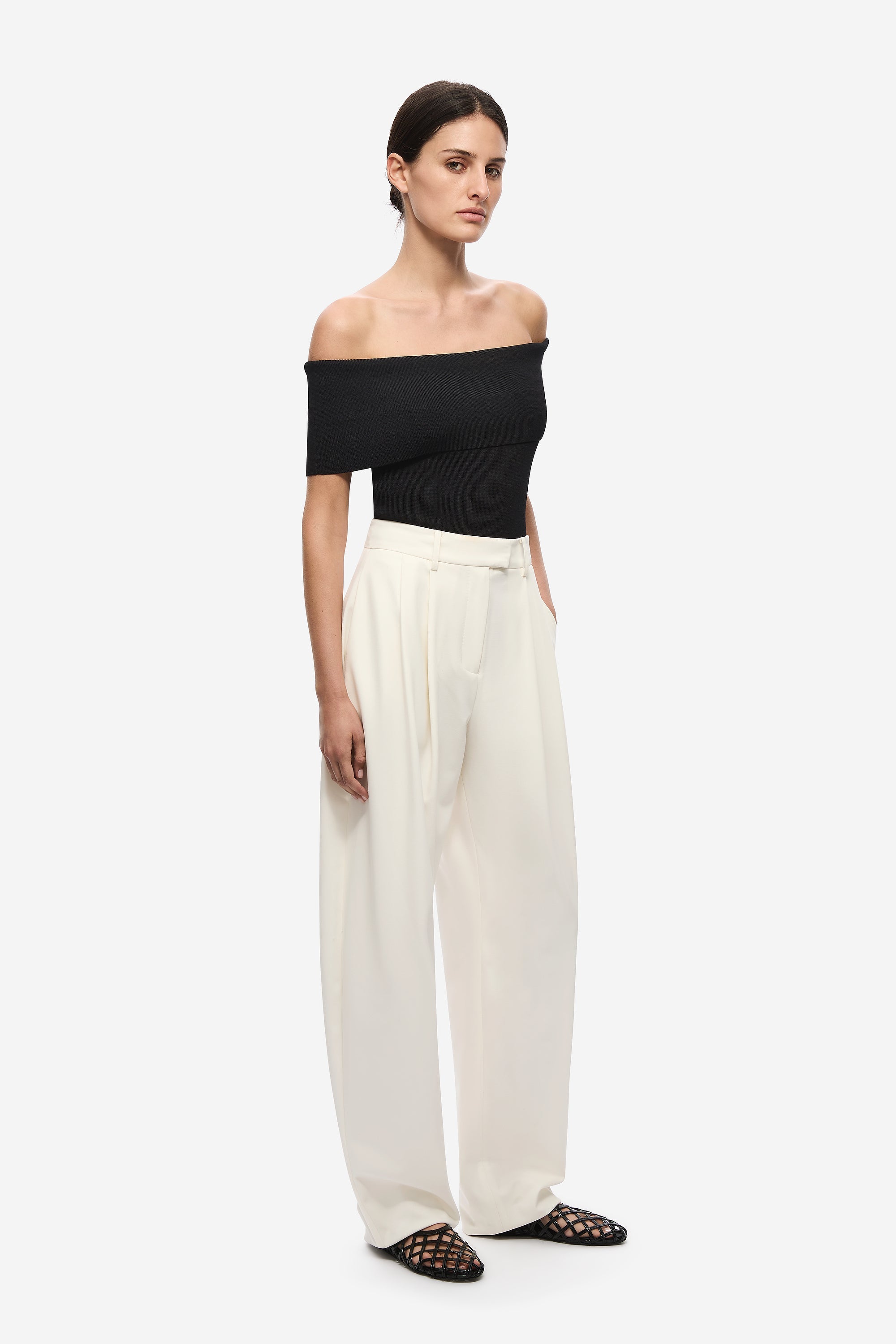 Black off-shoulder compact knit bodysuit, side profile with high-cut leg