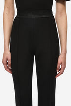 Black stretch crepe trousers close-up, smooth front with high-rise waist