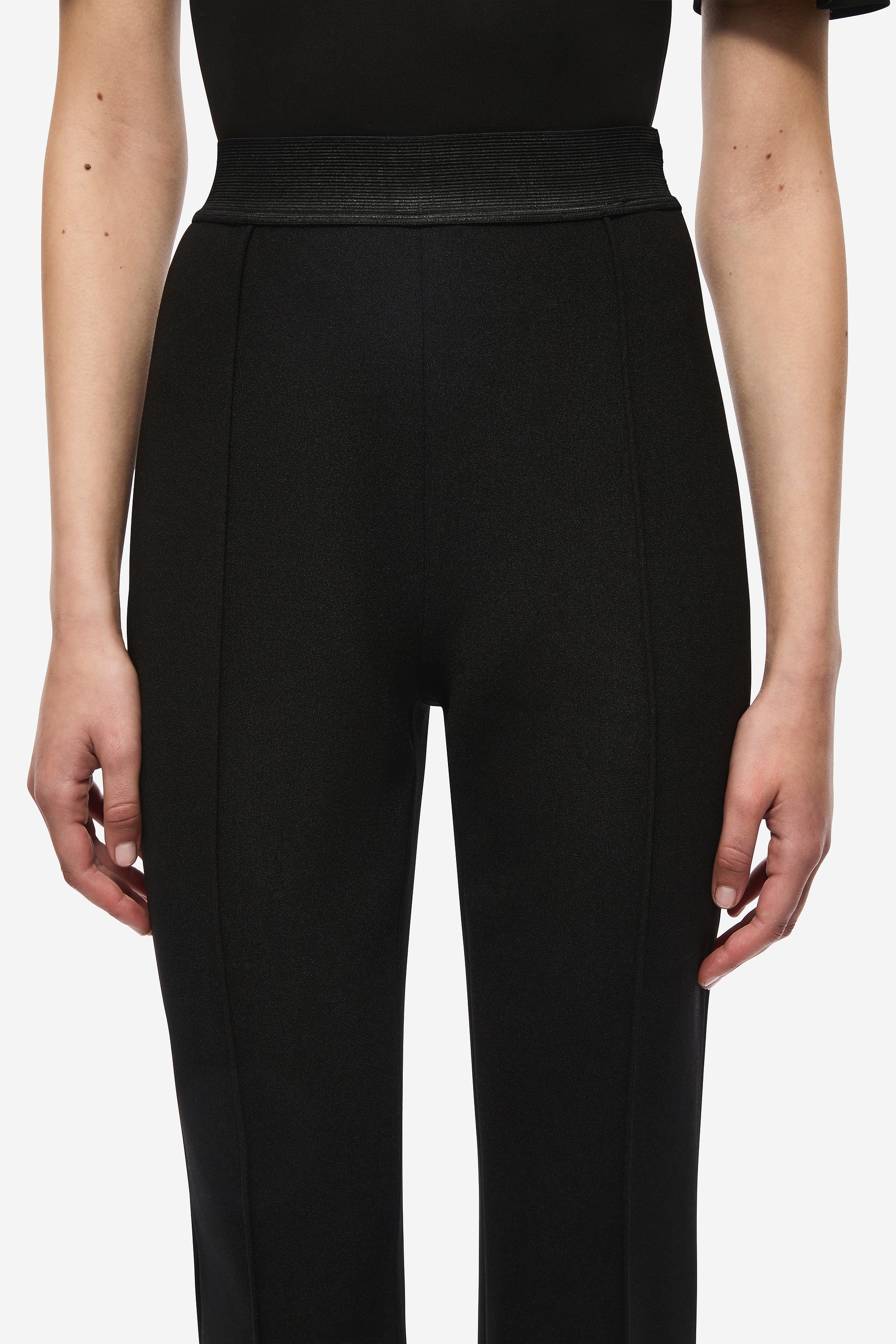 Black stretch crepe trousers close-up, smooth front with high-rise waist