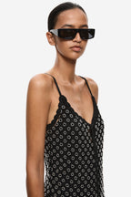 Close-up of black beaded crochet mini dress with lace trim straps and V-shaped neckline