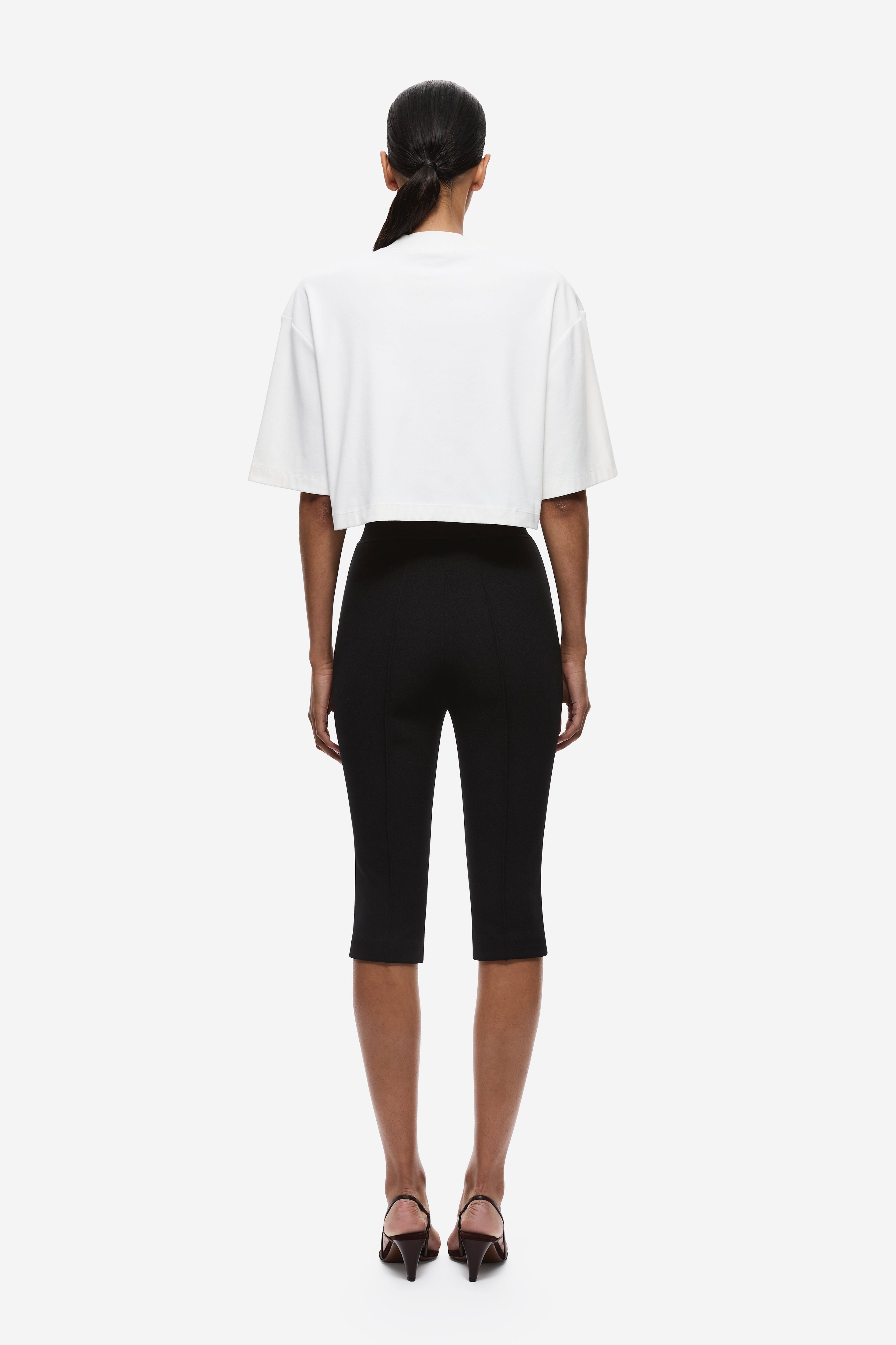 Black crepe capri pants from back, slim leg with mid-rise waist and ankle hem