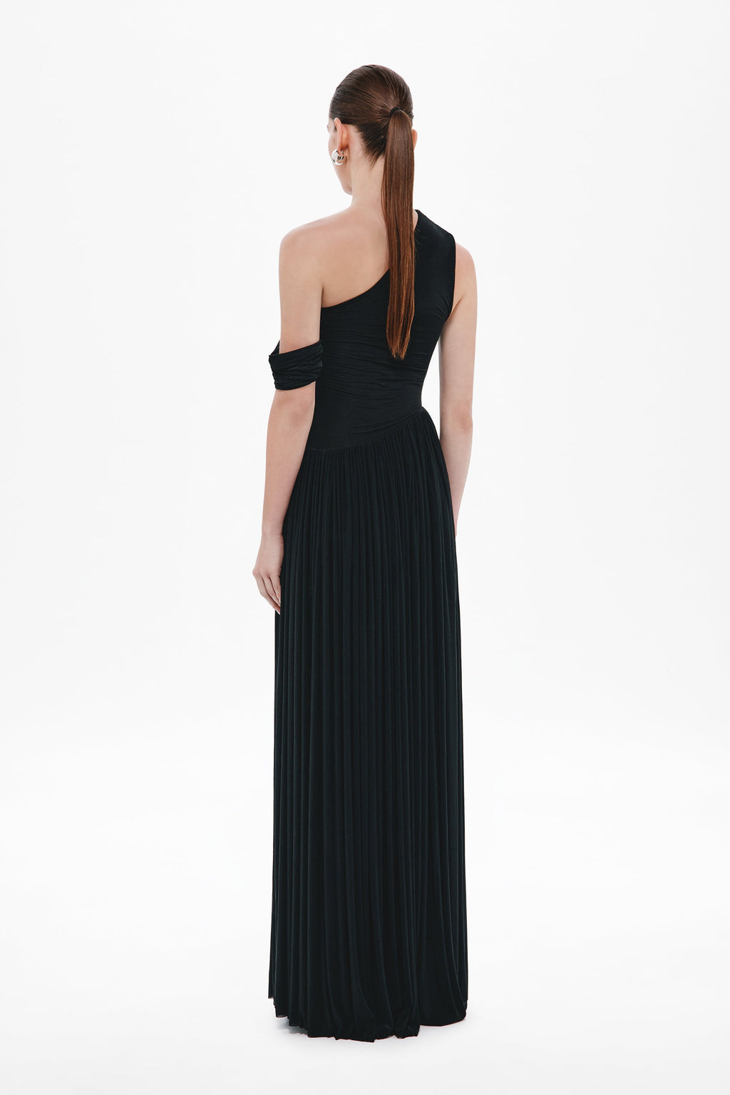 Black one-shoulder maxi dress shown from back, sleeveless with pleated column skirt