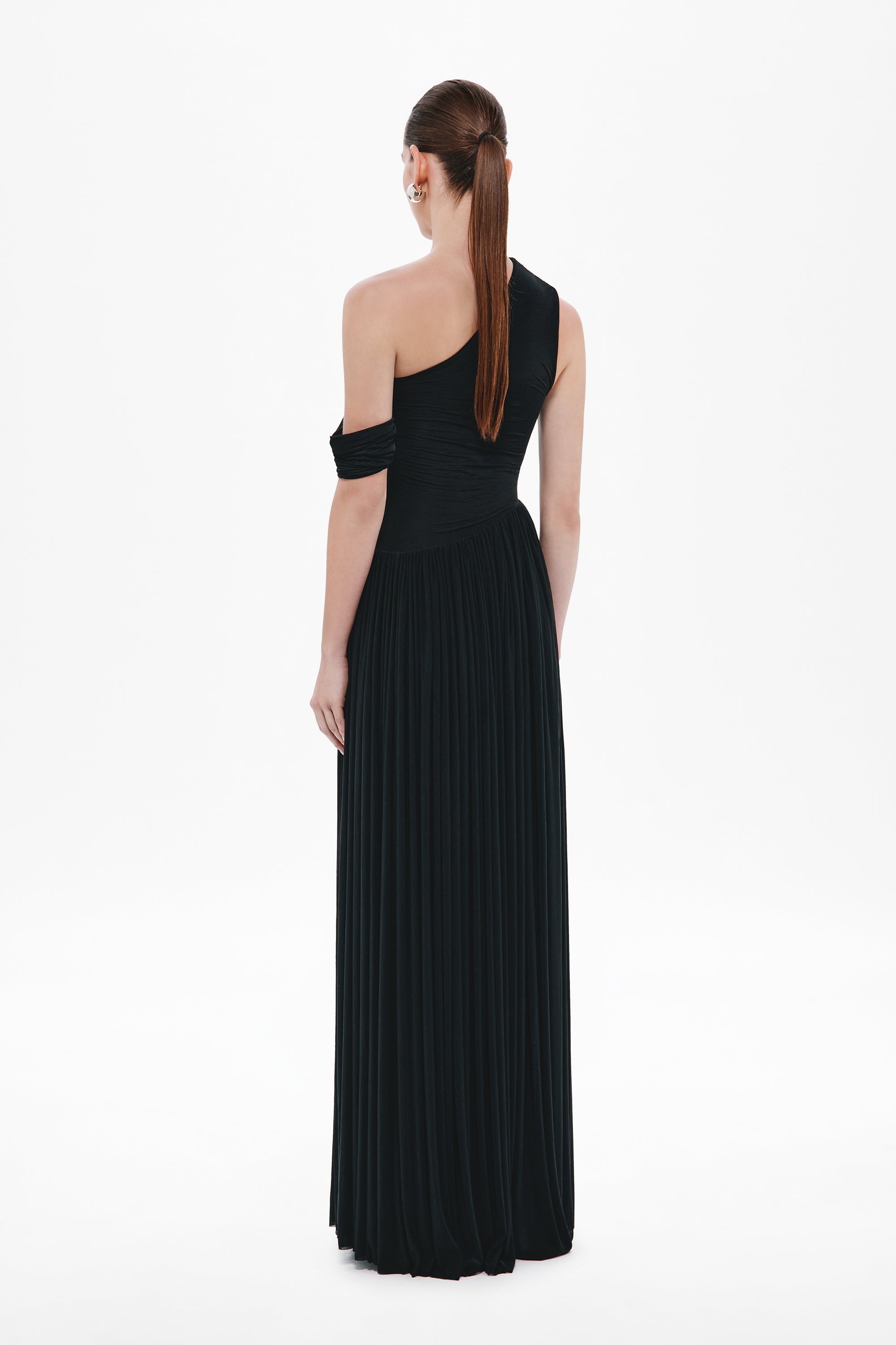 Black one-shoulder maxi dress shown from back, sleeveless with pleated column skirt