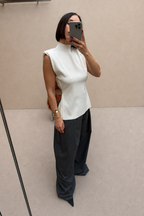 Ivory sleeveless knit top with open back and high neckline