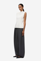Ivory sleeveless knit top with high neckline and open back
