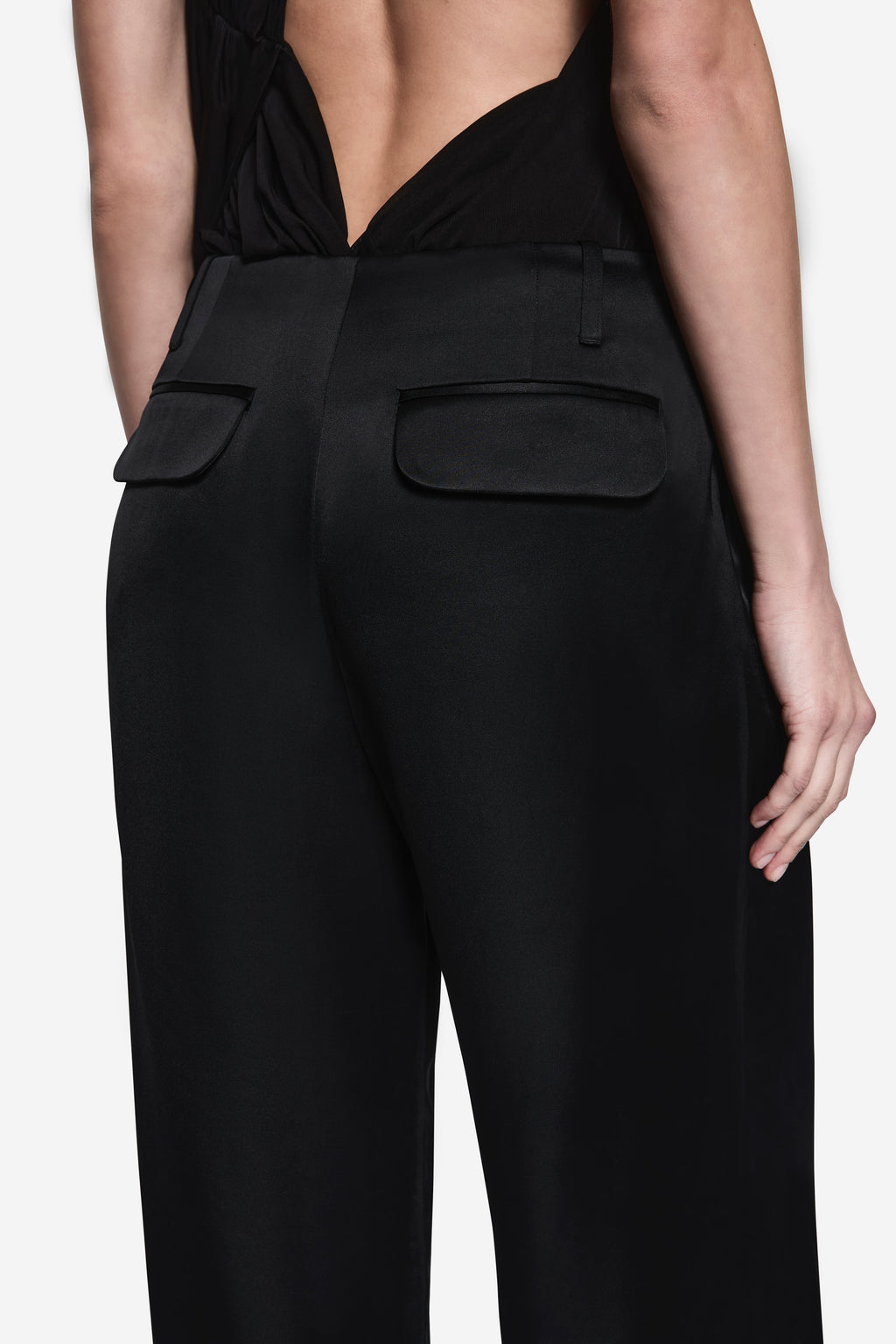 Black acetate pants close-up: high-rise waistband with patch pockets