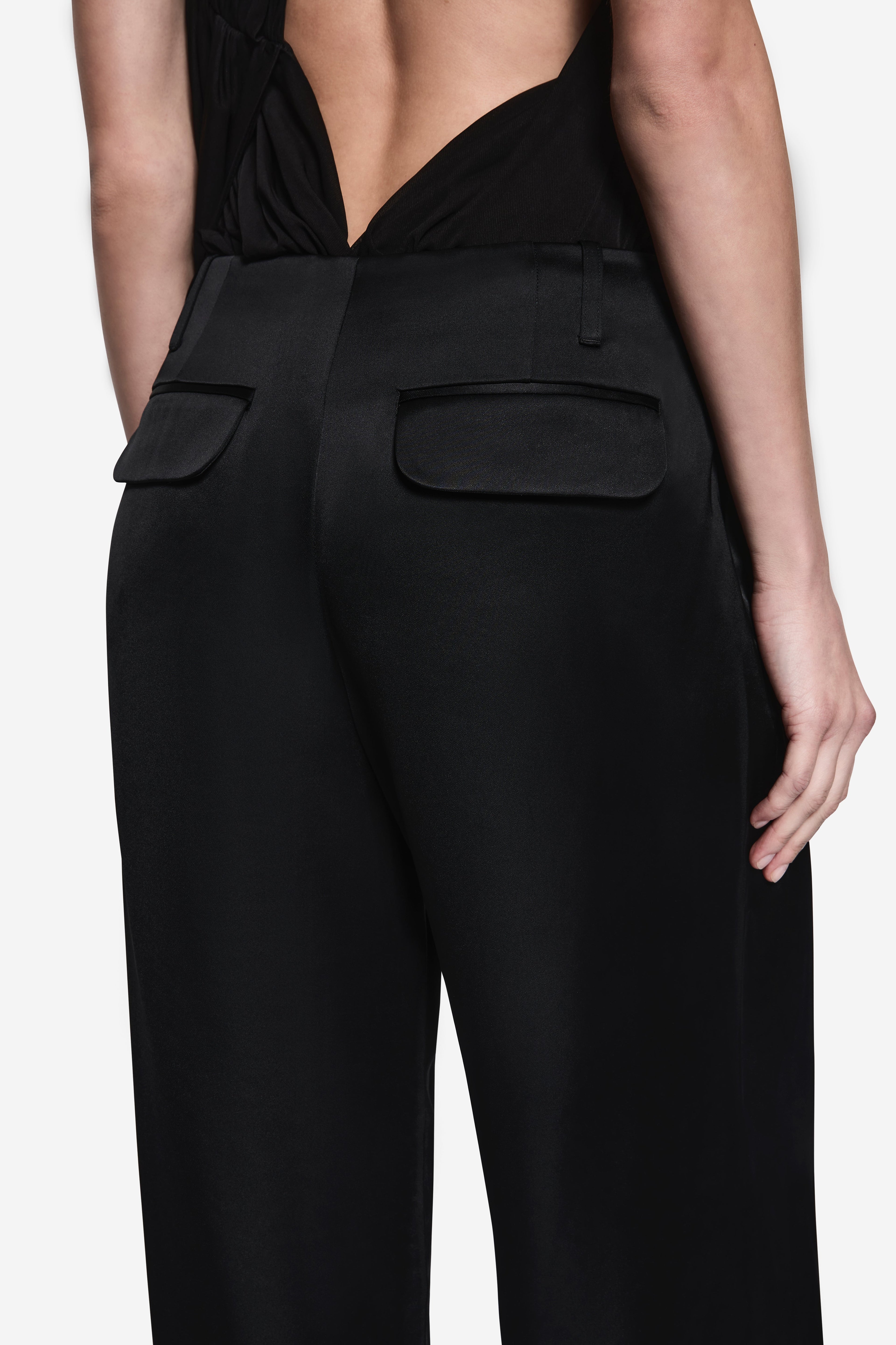 Black acetate pants close-up: high-rise waistband with patch pockets
