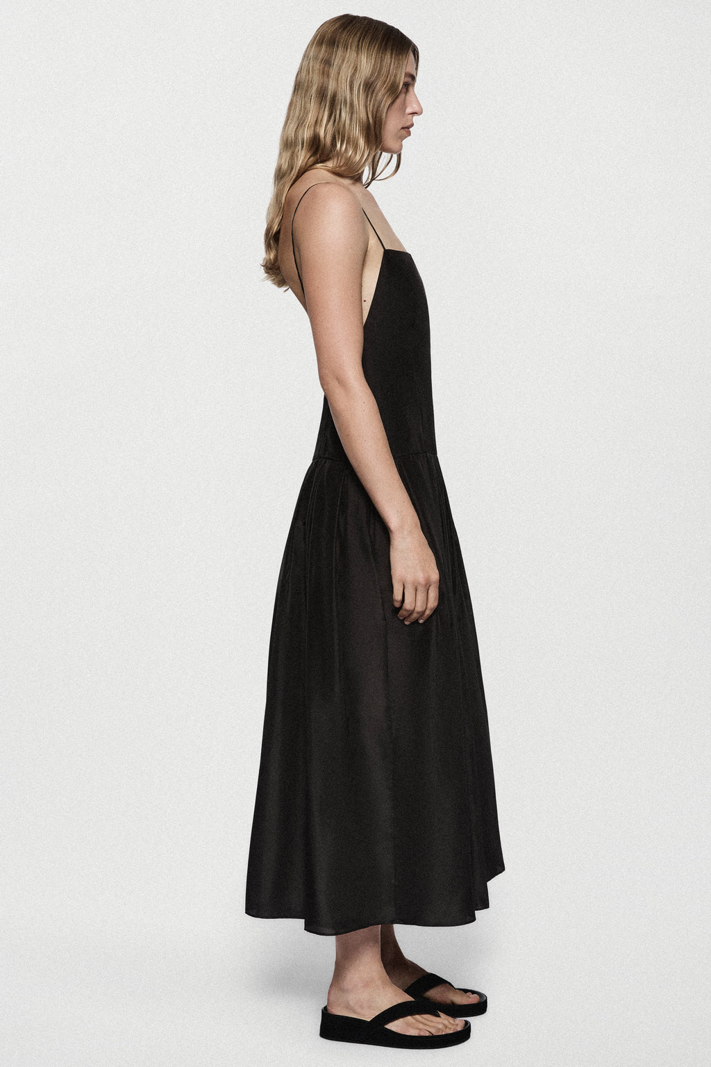 Black silk sundress profile view with spaghetti straps and full gathered skirt