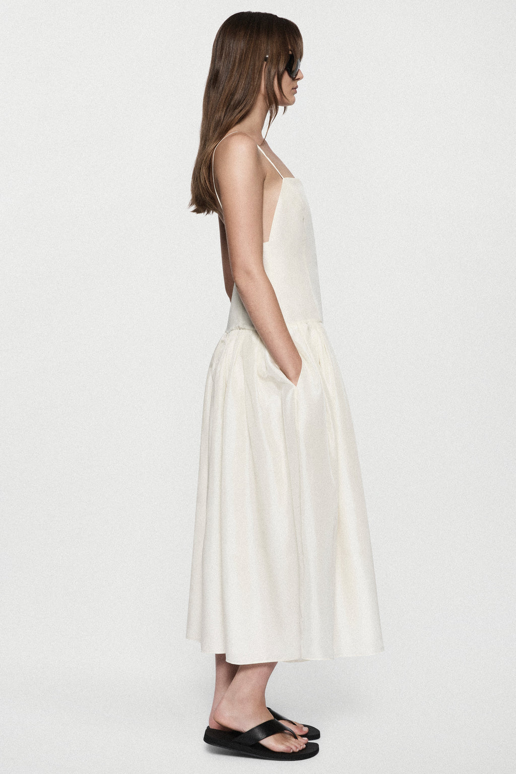 Winter white silk sundress with spaghetti straps and tiered skirt, side view.
