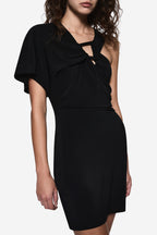 Black asymmetric mini dress close-up: draped knot neckline and side cutout