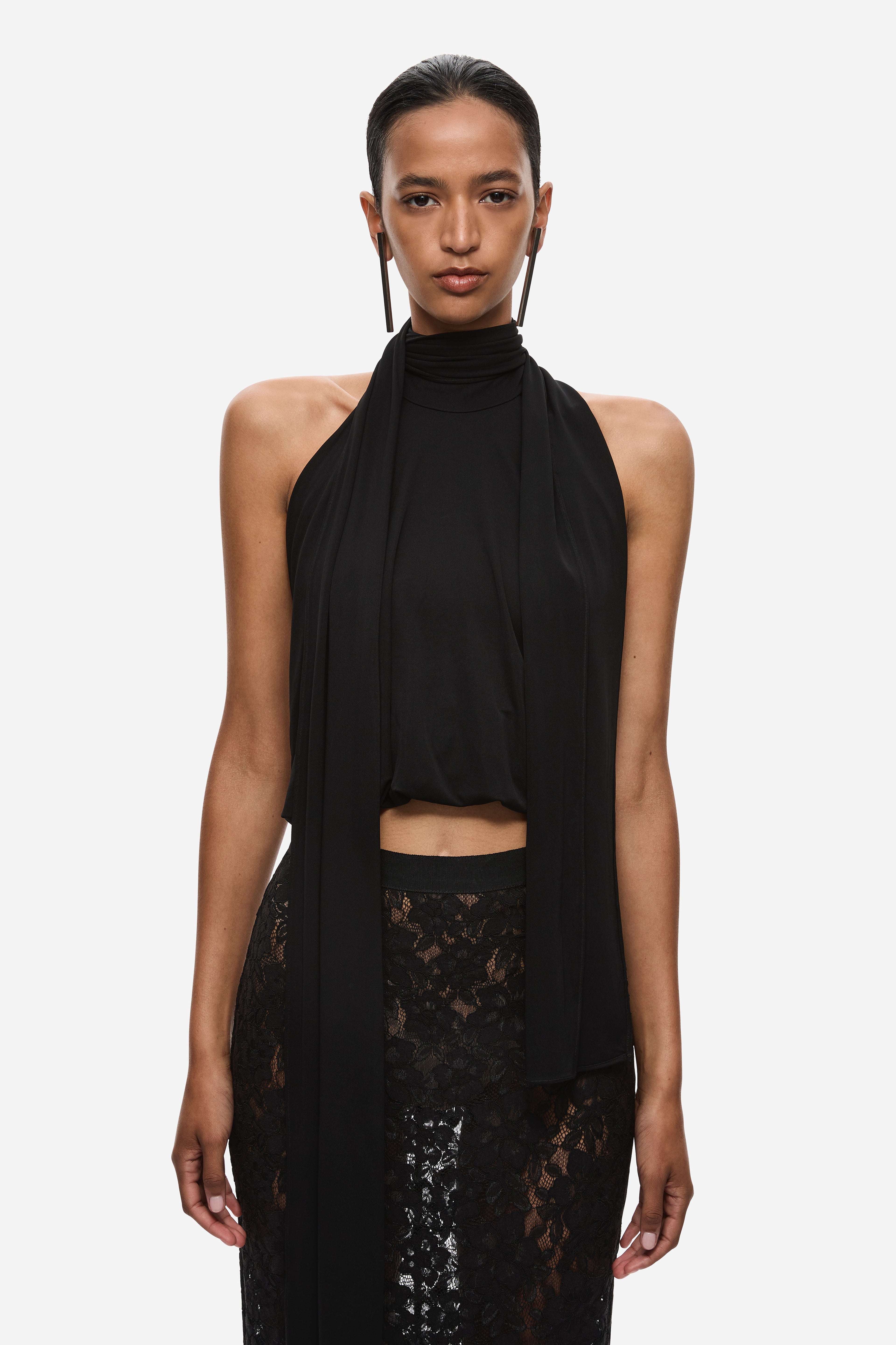Black halter jersey top with draped sash, lace panel, and midriff cutout