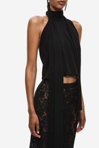 Black sleeveless halter jersey top with high neck, draped sash, and lace inserts