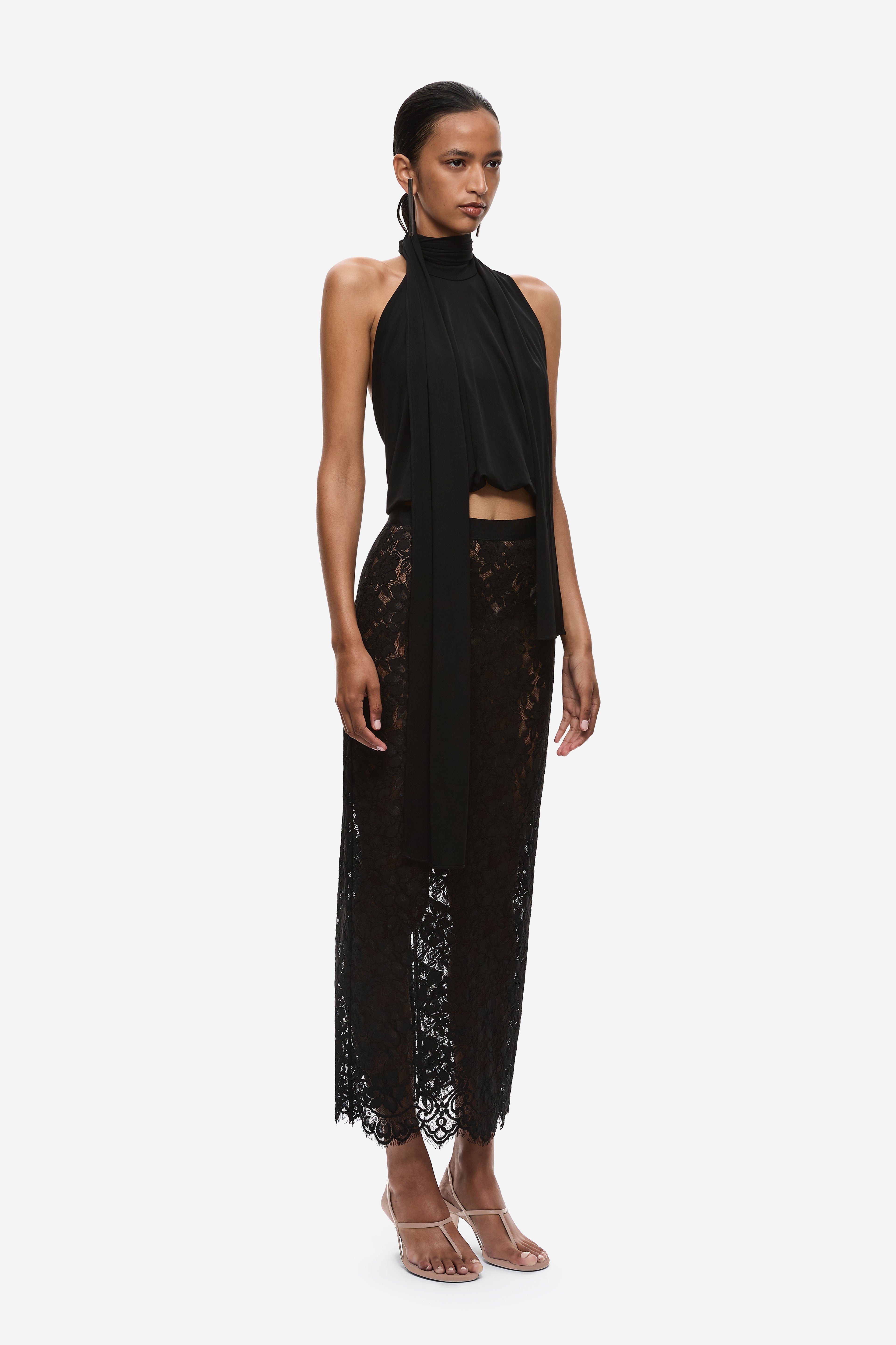 Black halter jersey top with high neck, draped sash, and lace hem panel