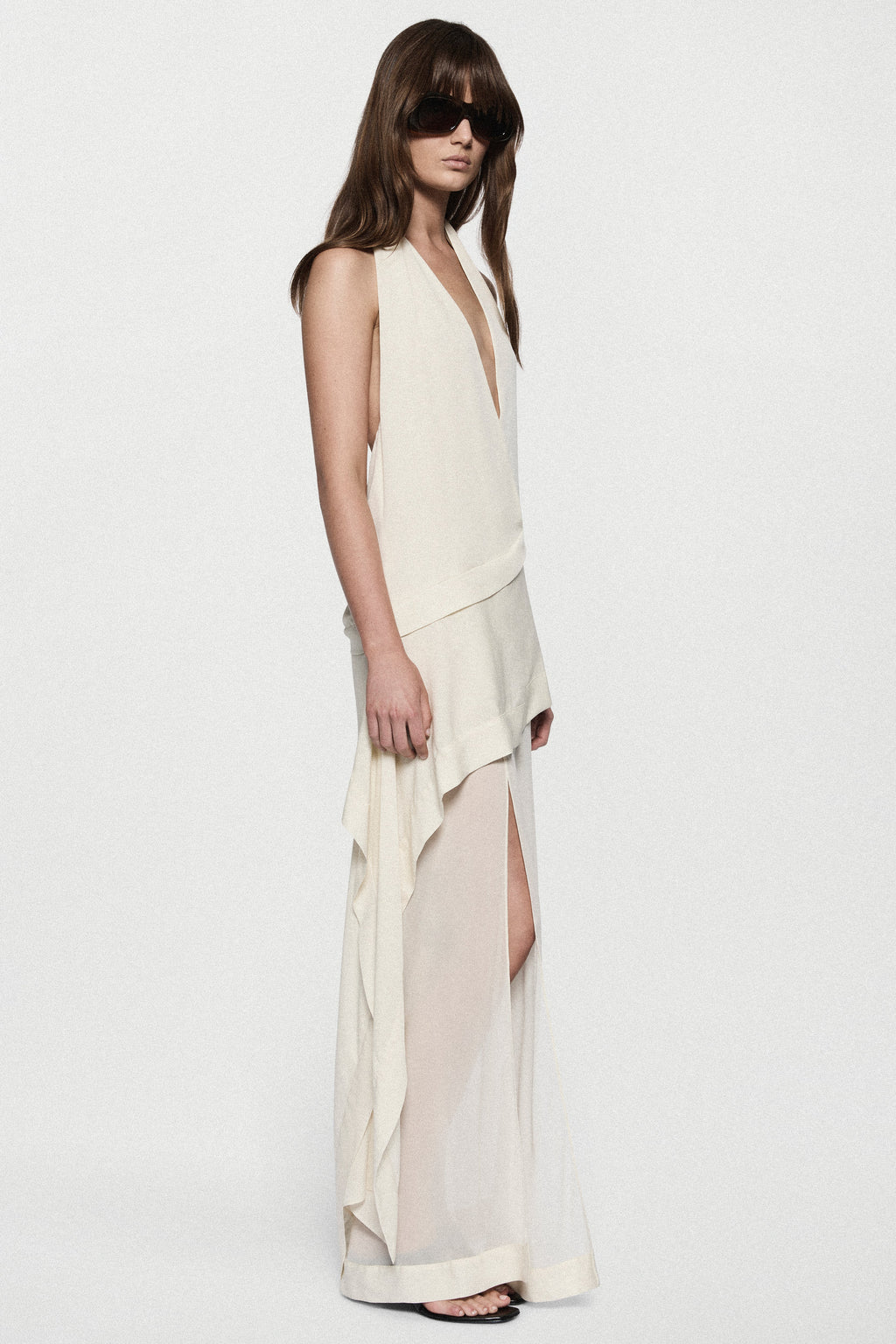 Off-white silk halter maxi dress with V neckline and side slit over layered hem