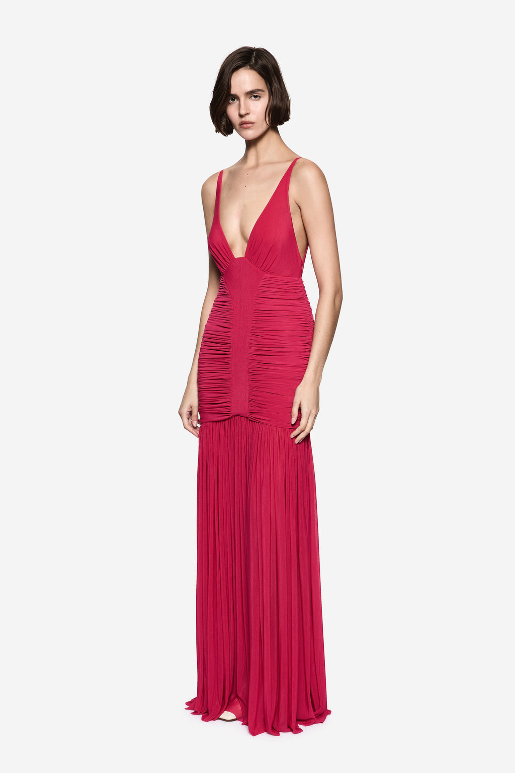 Hot pink sleeveless jersey maxi dress with deep V neckline and ruched bodice, fringe hem